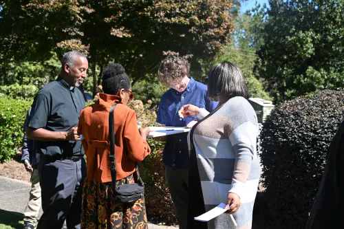 Sam Putt, a summer intern for the Presbyterian Ministry at the United Nations, assists members of Hillside Presbyterian Church in adding leaves of justice to the tree of life during a ritual of communal witness.  
