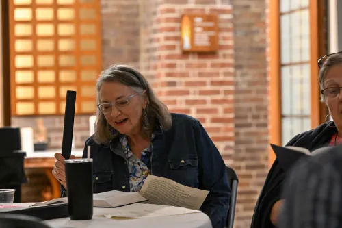 A woman sitting at a table plays a chime