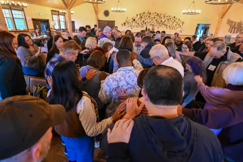A cloud of witnesses pray and lay hands on the Rev. Michael Gehrling at the 1001 NWC annual gathering in 2026.
