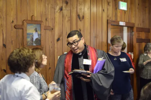 Preacher in formal clothing speaks with someone