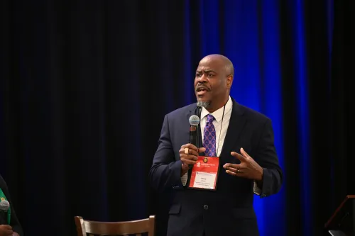Man in a suit gestures while speaking