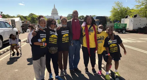 A Black man standard with a group of Black youth outside the US Capitol building.