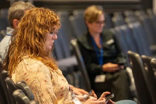 two women listen to an unseen speaker