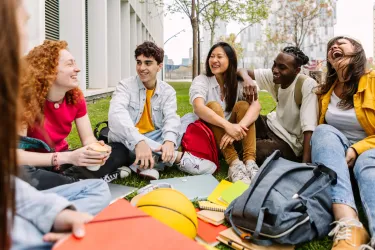 young adults sitting in circle smiling