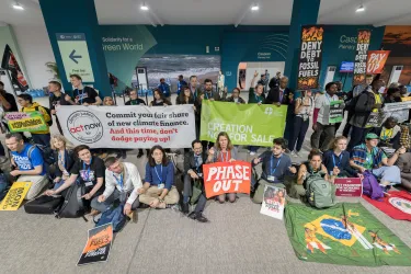 Group of people with Act Alliance holding climate change signs