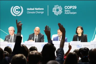 group of people sitting behind podium at COP29