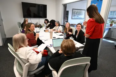 Women gathered around a long table at an office