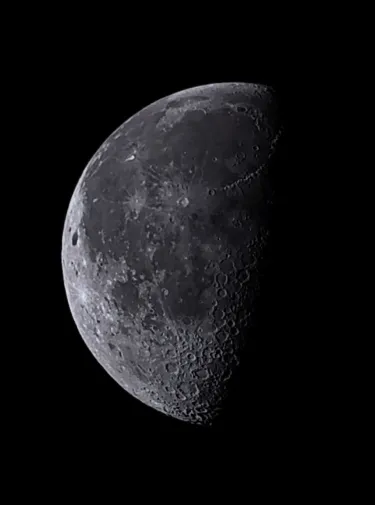 quarter moon with craters and seas visible