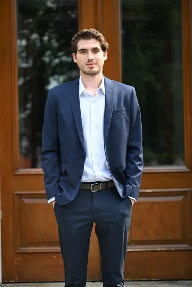 Young man in suit standing with hands in his pockets