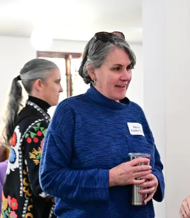 Woman in blue sweater and holding coffee cup