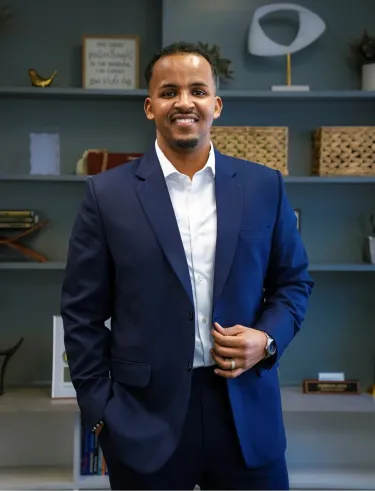 Man in suit posing in what looks like office setting