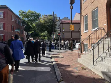 A group of people walking from St. George's Historic Church to Mother Bethel A.M.E.
