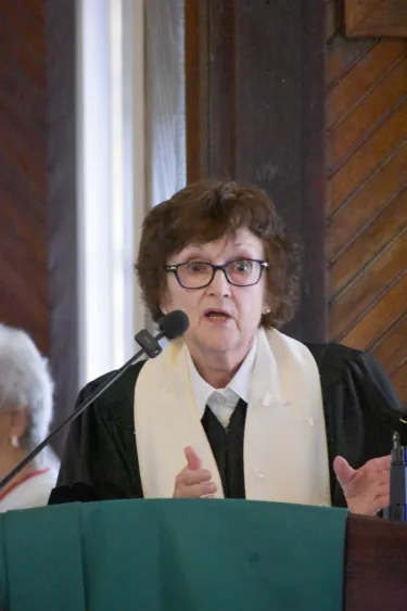 Woman speaks at church while wearing her ministerial robe 