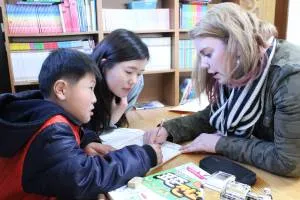 Molly working with a Korean youth on their English homework.