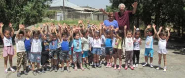 Mr. and Mrs. Kassouni with children all rasing their hands