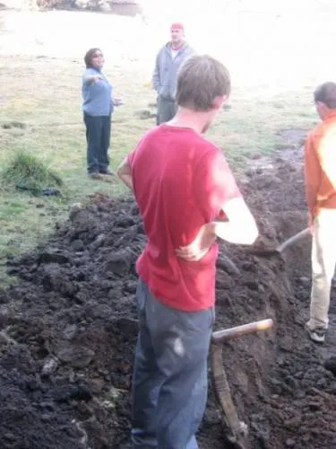 Angelica gives instructions to Jed as volunteers from the U.S. help in the construction of an irrigation system.