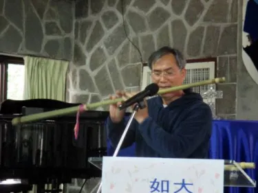 An aboriginal musician playing one of the long bamboo flutes that he crafted