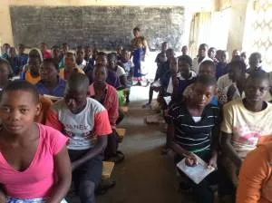 The same classroom with the students seated on the new benches