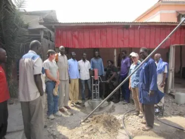 Rev. Paska turning a water pump at a training site in South Sudan