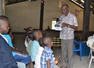 Tatu Celestin teaches Sunday School in Kananga using the new book of lessons and pictures