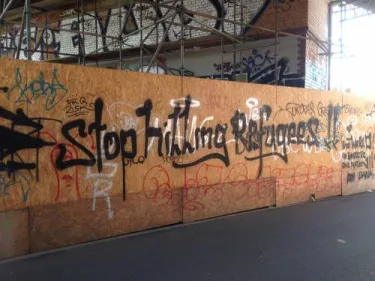 Graffiti in a park advocating for refugee assistance