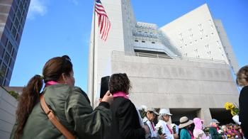 People standing outside a federal building for a vigil
