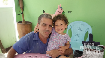 A man and a little girl in a room painted green.