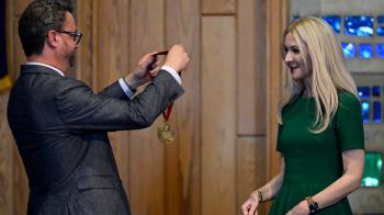 A man presents a woman with a medal 