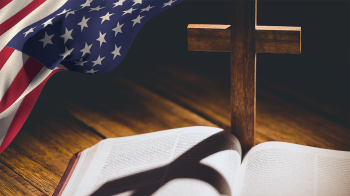 Image of bible and cross with an american flag to the side. 