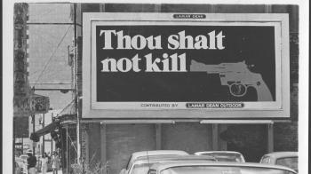 Billboard that reads "Thou Shalt Not Kill" with a grey image of a handgun to the right of it.