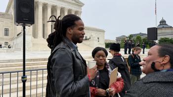 Paul Beaubrun, a Haitian singer, speaks with advocates Guerline Jozef and Dr. Bernadette Fouché in front of the U.S. Supreme Court on April 29, 2026. Photo by Cindy Corell.