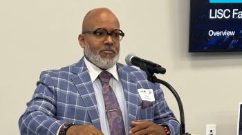 Man in a snazzy suit speaks at a lectern