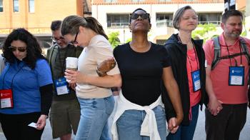 Attendees of Healing Not Harm: A Walk to End Gun Violence, which went from Pere Marquette Park to Milwaukee City Hall on June 27, 2026, grasp hands as they are led in prayer. 