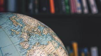 Close up of a globe with a bookshelf behind it