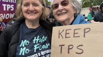 Two women holding a Keep TPS sign