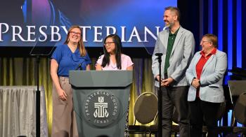 Four people standing in front of podium at GA227