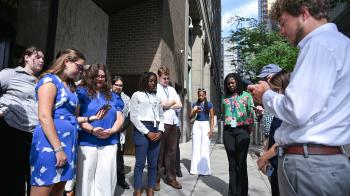 A group of young people pray on the sidewalk in New York City