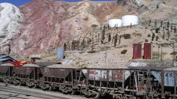 A mountainous area with older looking railcars