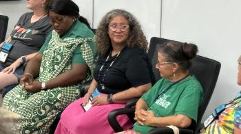 Three women participate in a casual conversation. 