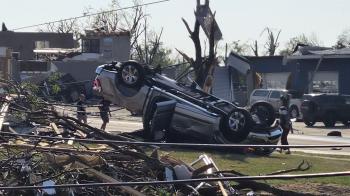An overturned car and other damage in a residential area