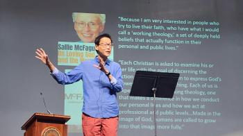 William Yoo speaks near a slide