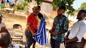 Indigenous elders welcome the Center for the Repair of Historic Harms' director, Rev. Jermaine Ross-Allam with the gift of a woven garment in Liberia, 2025. (Photo by James Norman)