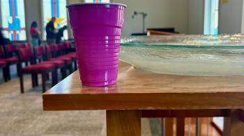 Pink Solo Cup holds holy water near baptismal font in Harrington Chapel at Columbia Theological Seminary during UKirk retreat.