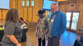 Rev. Marta Pumroy-Cordero prays with PL&amp;W Board co-chairs