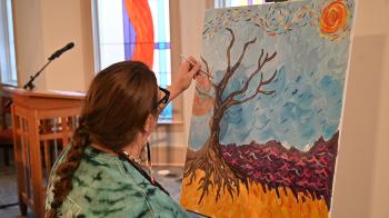Lauren Christian paints Van Gogh-inspired leaves in worship at the 2026 Jesus and Justice Young Adult Advocacy Conference. 