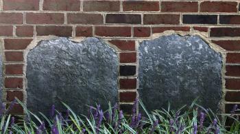 Two tombstones embedded into the exterior brick wall of the Presbyterian Historical Society building.