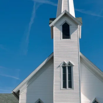 Small white rural church blue sky