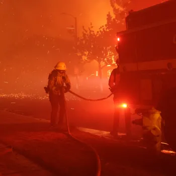 Los Angeles County firefighter handling a hose from the Cal Fire firetruck