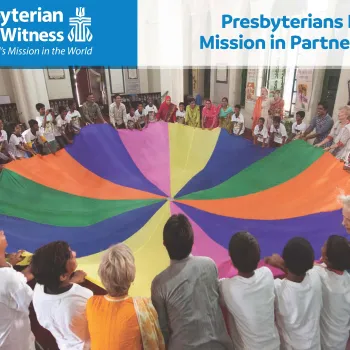 children holding onto colorful parachute