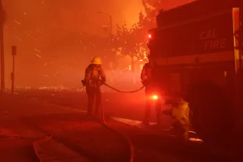 Los Angeles County firefighter handling a hose from the Cal Fire firetruck